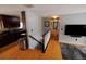 Hallway and kitchen with wood floors, view of the upstairs railing, and stainless steel appliances at 18908 E Napa Dr, Aurora, CO 80013