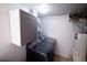 A modern laundry room with gray cabinetry, stacked washer and dryer, and water heater at 18908 E Napa Dr, Aurora, CO 80013