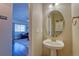 Cozy half bathroom with a pedestal sink and decorative mirror at 19225 E Carolina Pl # 102, Aurora, CO 80017