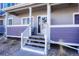 Townhouse entrance with charming steps, rocking chair, and a welcoming front door and colorful accent walls at 19225 E Carolina Pl # 102, Aurora, CO 80017