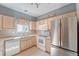 Well-lit kitchen features wooden cabinetry, modern appliances, and tile backsplash at 19225 E Carolina Pl # 102, Aurora, CO 80017