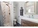 Modern bathroom featuring tiled shower with glass door, floating shelves, and a wood vanity at 17601 E Eastman Pl, Aurora, CO 80013