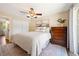 Bright bedroom with a ceiling fan, white walls, a queen sized bed, and a wooden dresser at 17601 E Eastman Pl, Aurora, CO 80013