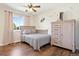 Bedroom with a ceiling fan, hardwood floors, neutral walls, a queen bed, and a dresser at 17601 E Eastman Pl, Aurora, CO 80013