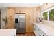 Kitchen showcases abundant wooden cabinetry, stainless steel refrigerator, and white countertops at 17601 E Eastman Pl, Aurora, CO 80013