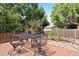 Outdoor dining on a brick patio next to a garden area with mature trees provides a serene setting for relaxation at 17601 E Eastman Pl, Aurora, CO 80013