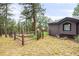 Backyard view featuring rustic wooden fence bordering the property and surrounding mature trees at 29432 Camelback Ln, Evergreen, CO 80439