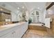 Elegant bathroom with double sinks, a large soaking tub, and marble tile at 29432 Camelback Ln, Evergreen, CO 80439