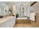 Spa-like bathroom with double vanity, soaking tub, and skylight at 29432 Camelback Ln, Evergreen, CO 80439