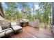 Inviting deck with a grill and seating, surrounded by lush greenery and trees at 29432 Camelback Ln, Evergreen, CO 80439