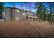 Exterior angle showing a two story home with a large picture window and ample surrounding trees at 29432 Camelback Ln, Evergreen, CO 80439