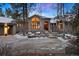 Two-story home with a walkway, gray exterior, and landscaping with rocks and trees at 29432 Camelback Ln, Evergreen, CO 80439