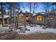 Stunning two-story home with a gray exterior, snow-covered landscaping, and a large window at 29432 Camelback Ln, Evergreen, CO 80439