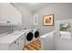 Bright laundry room with side-by-side washer and dryer, ample counter space, and neutral tones at 29432 Camelback Ln, Evergreen, CO 80439