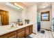 Well-lit bathroom with a dual-sink vanity, bright natural light, and a separate shower area at 1310 Spinnaker Trl, Monument, CO 80132
