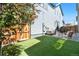 Beautiful backyard featuring artificial grass, patio, string lights, and wooden fence for privacy at 9768 E 62Nd Dr, Denver, CO 80238