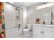 Bright bathroom featuring tub shower with tiled walls and a modern vanity with black hardware at 9768 E 62Nd Dr, Denver, CO 80238