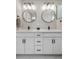 A well lit ensuite bathroom features a double sink vanity, matte black hardware, and modern light fixtures at 9768 E 62Nd Dr, Denver, CO 80238
