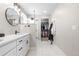 Well-lit bathroom featuring double vanity with quartz countertops, modern fixtures, and shower and closet access at 9768 E 62Nd Dr, Denver, CO 80238
