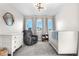 Cozy bedroom with modern light fixture, sitting chair, crib and dresser, and three windows letting in natural light at 9768 E 62Nd Dr, Denver, CO 80238