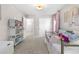 Bright bedroom featuring decor, plush carpet, a metal frame bed, a large window, a closet, and storage shelves at 9768 E 62Nd Dr, Denver, CO 80238