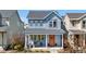 Charming two-story home showcasing a covered front porch with stylish seating and an eye-catching orange front door at 9768 E 62Nd Dr, Denver, CO 80238