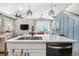 Stylish kitchen island with modern lighting, a stainless steel sink, and an open view into the living area at 9768 E 62Nd Dr, Denver, CO 80238