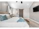 Bright main bedroom featuring a sliding barn door to the ensuite bathroom and neutral toned decor at 9768 E 62Nd Dr, Denver, CO 80238