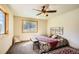 This cozy bedroom features a ceiling fan, a comfortable bed, and a natural light-filled window at 30570 Highway 72, Golden, CO 80403