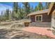 Side view of the cabin with a red tile patio at 30570 Highway 72, Golden, CO 80403