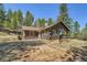 Charming log cabin home with a stone foundation, nestled among tall pine trees at 30570 Highway 72, Golden, CO 80403