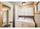 Functional laundry room with white washer, dryer, and overhead cabinets for storage at 30570 Highway 72, Golden, CO 80403