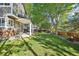 Spacious backyard with a well-maintained lawn, mature trees, and a charming covered patio area at 16342 Parkside Dr, Parker, CO 80134