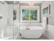 Elegant bathroom with a soaking tub, glass shower, and large windows overlooking the yard at 16342 Parkside Dr, Parker, CO 80134