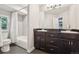 Well-lit bathroom with a double vanity, dark cabinets and shower-tub combo at 16342 Parkside Dr, Parker, CO 80134