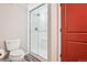 Bathroom with white subway tile shower, glass enclosure, and a red door at 16342 Parkside Dr, Parker, CO 80134
