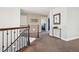 Bright hallway features neutral carpeting, wood railings, and decorative wall art at 16342 Parkside Dr, Parker, CO 80134