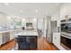 Modern kitchen with stainless steel appliances, white cabinets, a gray tiled backsplash, and a dark island at 16342 Parkside Dr, Parker, CO 80134