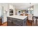 Kitchen with stainless steel appliances and a gray island, open to the dining and living rooms at 16342 Parkside Dr, Parker, CO 80134