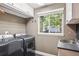 Well-organized laundry room with sleek appliances, a utility sink, and ample storage cabinets at 16342 Parkside Dr, Parker, CO 80134