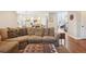 Open-concept living room with a comfortable sectional couch, dark hardwood floors, and a view into the kitchen at 16342 Parkside Dr, Parker, CO 80134