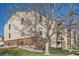 A multi-level condo building with brick and siding, green lawn, and mature landscaping at 499 Wright St # 308, Lakewood, CO 80228