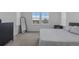 Bright bedroom with large windows showing neighborhood homes, dresser, mirror and bed at 8550 Cheraw St, Littleton, CO 80125
