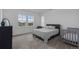 Bright bedroom features two windows and a gray bed with a baby crib nearby at 8550 Cheraw St, Littleton, CO 80125