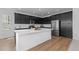 Spacious kitchen with large island, stainless steel appliances, and sleek black cabinetry at 8550 Cheraw St, Littleton, CO 80125