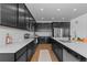 Modern kitchen features black cabinetry, stainless steel appliances, and bright white countertops at 8550 Cheraw St, Littleton, CO 80125
