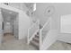 Open staircase with modern white railings and carpeted steps in a bright, open foyer at 8550 Cheraw St, Littleton, CO 80125