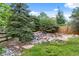 Serene backyard featuring a rock garden and mature trees offering privacy and natural beauty at 11821 Joplin Ct, Commerce City, CO 80022