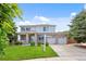 Charming two-story home featuring a brick facade, well-manicured lawn, and attached two-car garage at 11821 Joplin Ct, Commerce City, CO 80022