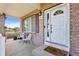 Inviting front porch with seating area, showcasing brickwork and an attractive front door at 11821 Joplin Ct, Commerce City, CO 80022